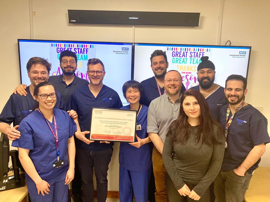Wide angle photo of the Gynaecological Oncology team holding the accreditation certificate. 